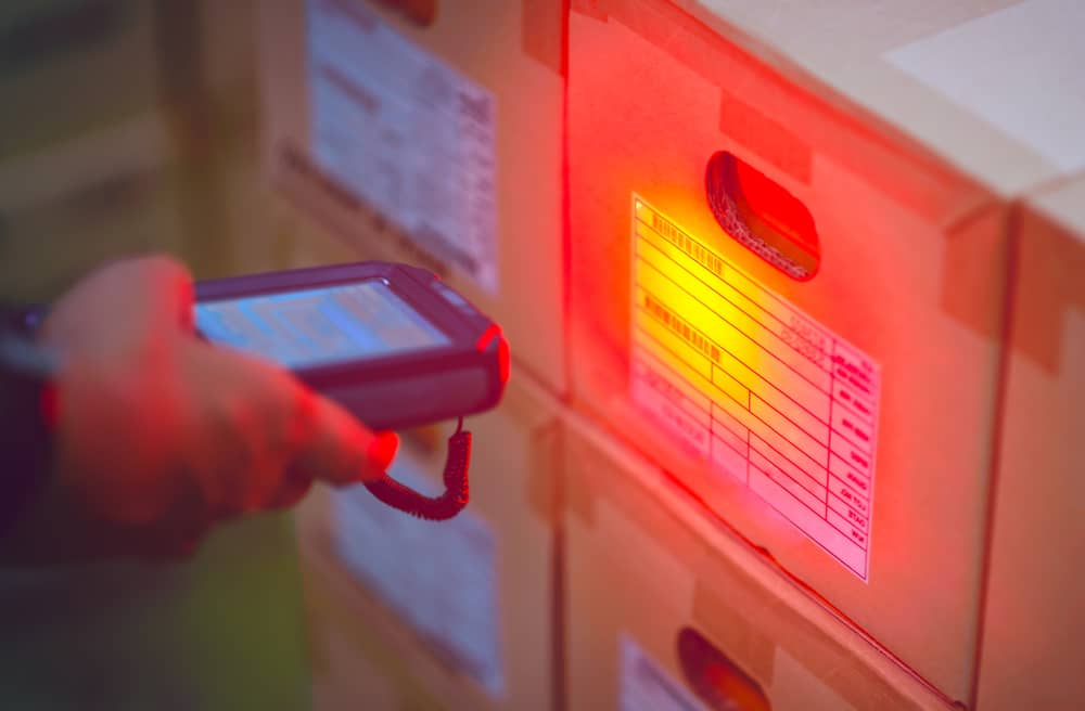 Worker scanning a shipping box for records