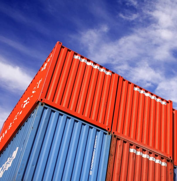 Colorful shipping containers stacked with blue sky in the background