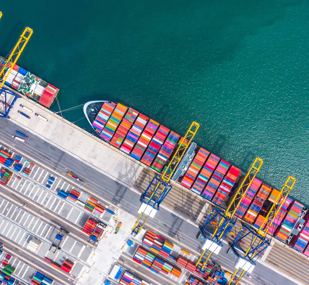 Overhead view of shipping port with full ship of shipping containers