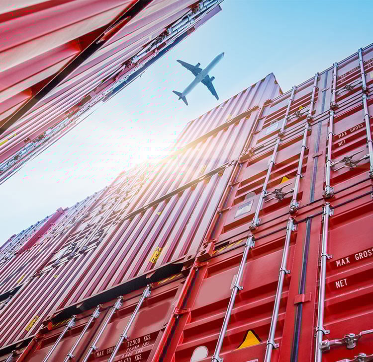plane flying over shipping containers plane flying over shipping containers