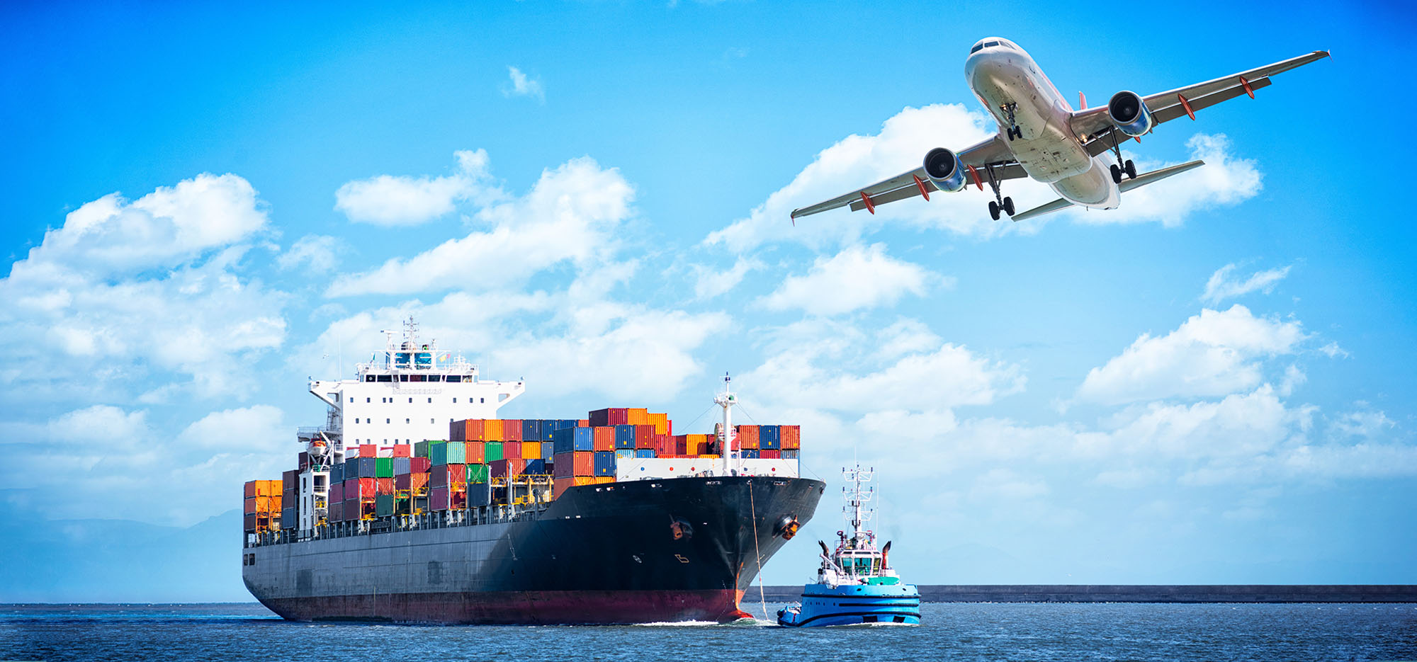 Freight ship on the ocean with airplane above