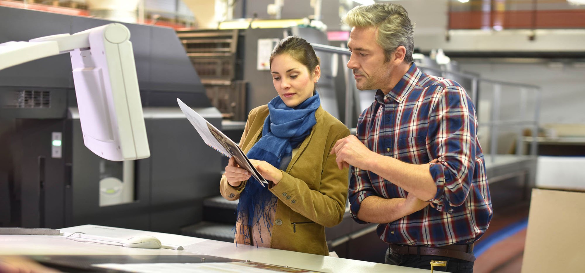 Man and woman discuss manufacturing specifications in factory